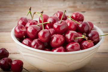 Red cherries in a white bowl