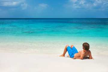 Fototapeta na wymiar Young man relaxing on the beach