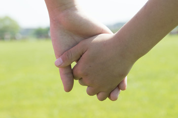 The hands of children holding hands in the park