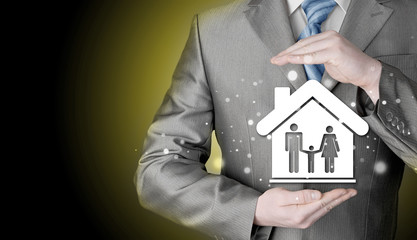 businessman protecting family in home with hands