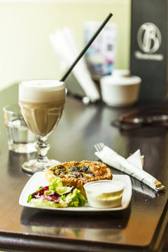 French cuisine: the Quiche pie served with sauce and greens 
