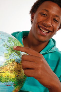 Jugendlicher Schwarzer zeigt auf einem Globus Deutschland
