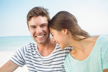 Obraz premium happy couple smiling together in front of the sea 