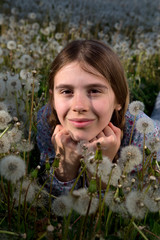 Pretty Girl Resting on Dandelions Field on Sunny Spring Day