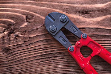 Metal bolt cutter on wooden board construction concept
