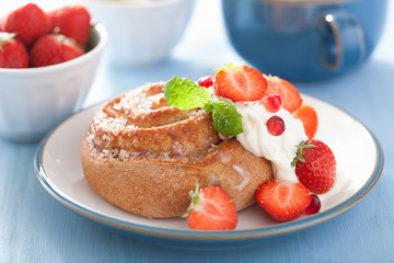 sweet cinnamon roll with cream and strawberry for breakfast