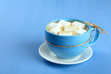 A cup of hot chocolate with marshmallows on the wooden background
