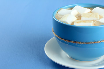 A cup of hot chocolate with marshmallows on the wooden background