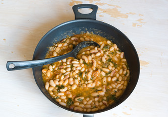 Georgian national dish lobio in a pan on a tacky wooden table