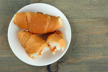 Croissants in a plate on a wooden background