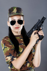 Female soldier in camouflage uniform with weapon 