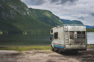Camper van parked on a beach, mountain range landscape