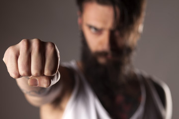 a young man with a beard showing fist