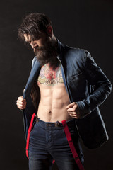 a young man with a beard wearing a denim jacket and jeans