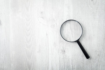 Magnifying glass on wooden table, Search and discover symbol