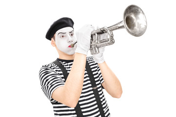 Young male mime artist playing a trumpet