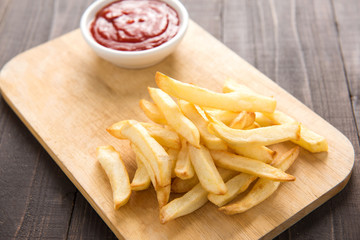 French fries with ketchup on wooden background