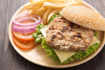 BBQ hamburgers with french fries on wooden background.