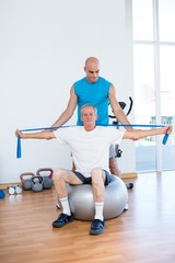 Trainer examining his patient back 