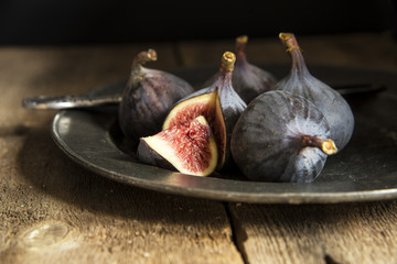 Fresh figs in moody natural lighting set with vintage retro styl