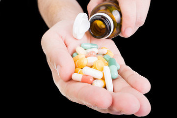 Pills being pored out of the bottle in patient's hand