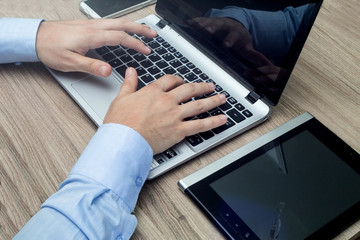 mani sulla tastiera di un notebook in ufficio di lavoro
