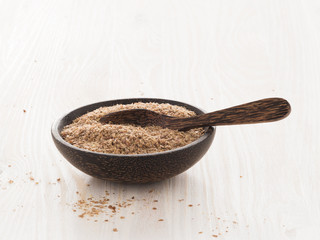 Leinsamen geschrotet, Holzschale, Holzlöffel, Brot backen