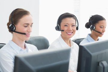 Business people with headsets smiling at camera 