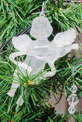 Detail of green Christmas tree, ornaments, angel, stars 