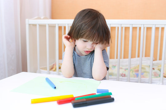 Tired little boy with felt pens