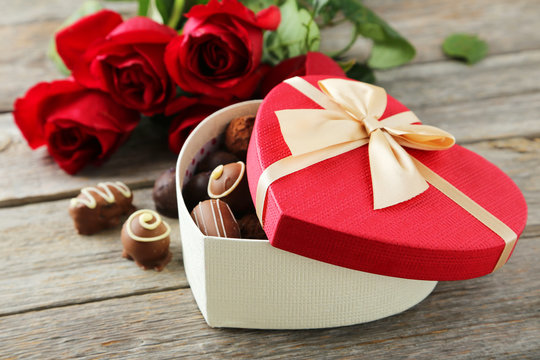 Beautiful heart gift box with chocolates on grey wooden backgrou