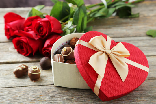 Beautiful heart gift box with chocolates on grey wooden backgrou