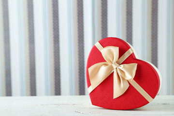 Beautiful heart gift box on white wooden background