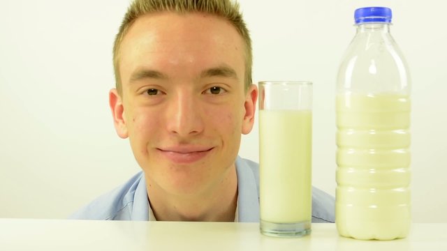 glass of milk and man smiles - white background studio