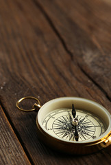 Compass on brown wooden background