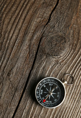 Fototapeta na wymiar Compass on brown wooden background