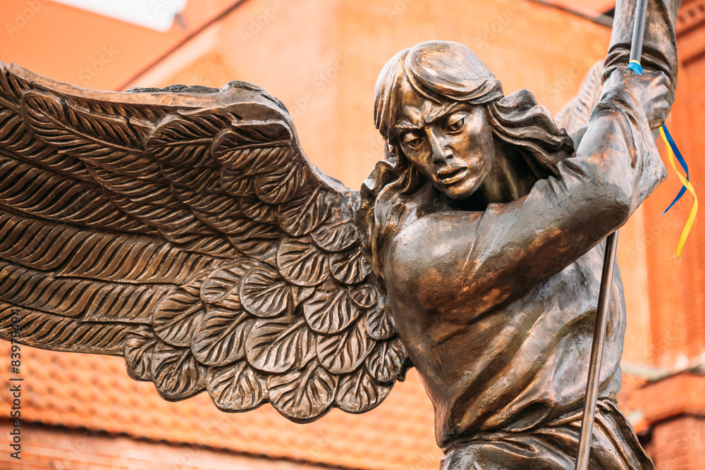 Wall mural statue of archangel michael with outstretched wings before red c