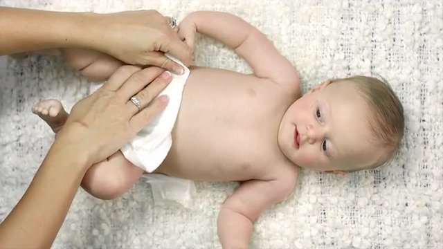 Birds eye view of a baby getting its daiper put on by its mother