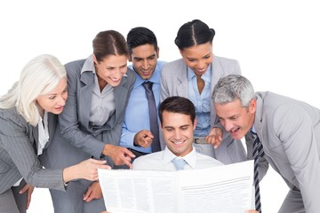 happy business people looking at newspaper 