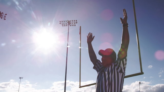 A football referee puts his hands over his head after a field goal