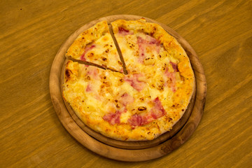 Pizza Hawaii auf einem Holzbrett