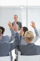 Naklejka na ściany i meble Business team raising hands during conference