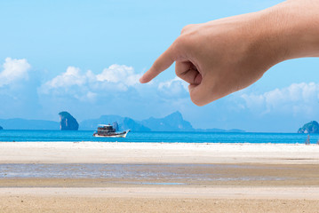 Finger pointing at a picture beach. Dream concept