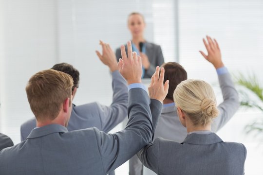 Business team raising hands during conference