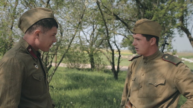 Two young soldier in uniform standing in the forest and smoke