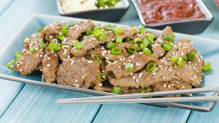 Bulgogi - Korean grilled beef with side dishes and lettuce