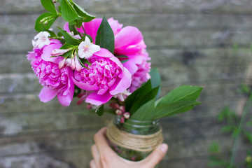 bunch of pink peonies in jar