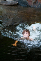 young boy playing in a lake 