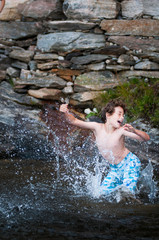 young boy playing in a lake with a boogie board