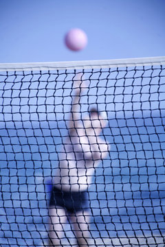 Uomo gioca a beach volley in spiaggia 